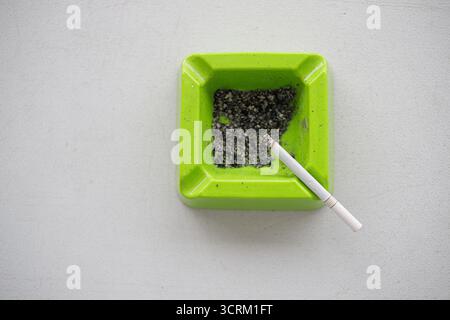 Lighting cigarette in ashtray isolated on white background Stock Photo