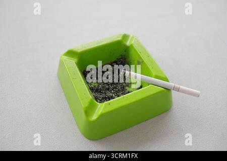 Lighting cigarette in ashtray isolated on white background Stock Photo
