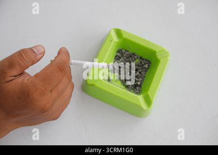 Lighting cigarette in ashtray isolated on white background Stock Photo