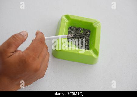 Lighting cigarette in ashtray isolated on white background Stock Photo