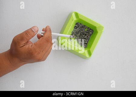Lighting cigarette in ashtray isolated on white background Stock Photo