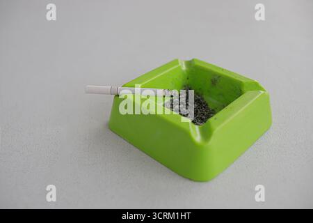 Lighting cigarette in ashtray isolated on white background Stock Photo