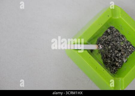 Lighting cigarette in ashtray isolated on white background Stock Photo