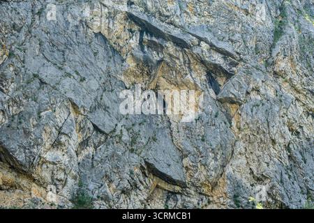 Close-up of a rugged rock surface with various textures and colors. Stock Photo