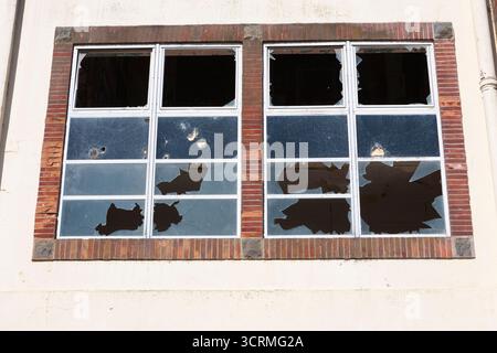 Broken windows in the abandoned Torridge Vale Dairy, closed in 1993 and now derelict and a magnet for urban explorers: Great Torrington, Devon, UK Stock Photo
