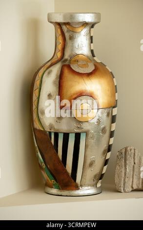 Bright, modern, colourful vase with abstract geometric decoration, Lustrous finish, black, white, silver, gold, green, copper colours. Australia. Stock Photo
