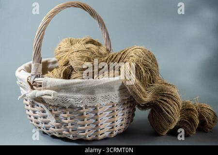 Wicker basket with linen thread on a gray background Stock Photo