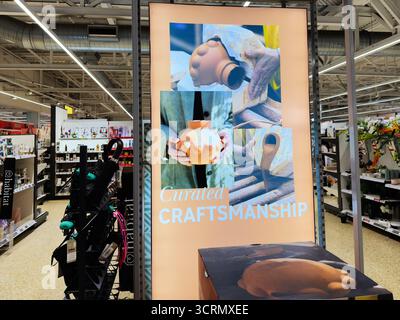 Salford, UK - September 25, 2025: Retail display featuring a large poster titled Curated Craftsmanship with pottery and handmade pieces. Stock Photo