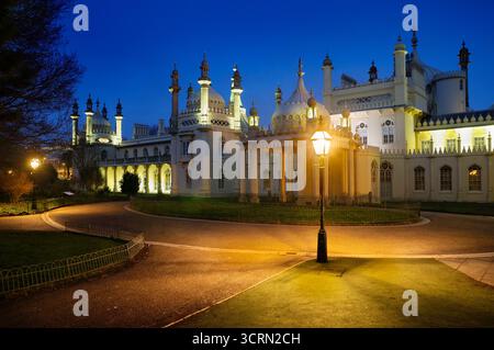 The historic Royal Pavilion / Brighton Pavilion building illuminated at dusk / night inside grounds of Royal Pavilion Garden, East Sussex, England, UK Stock Photo