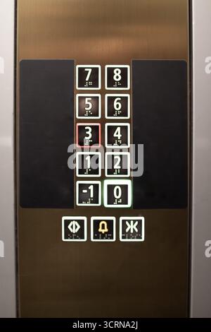 Elevator control panel displaying floor numbers and buttons in a modern building Stock Photo