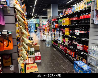 Manchester, UK - September 25, 2025: A bustling UK SPAR store aisle filled with drinks, snacks and everyday groceries on shelves, showcasing a lively Stock Photo