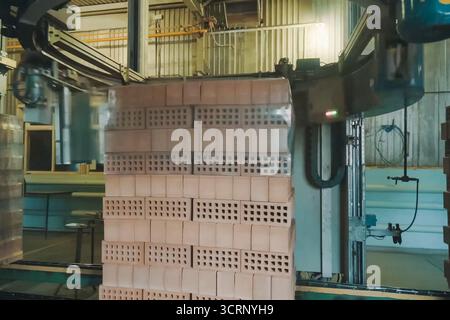 Wrapping a transport film of a brick pallet. Brick production, hollow ceramic bricks factory. Brick production, bricks factory. Stock Photo