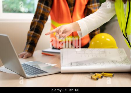 Engineers team use laptop and check the blueprint on site. Contractor and inspector inspection construction during project.civil Forman check quality Stock Photo