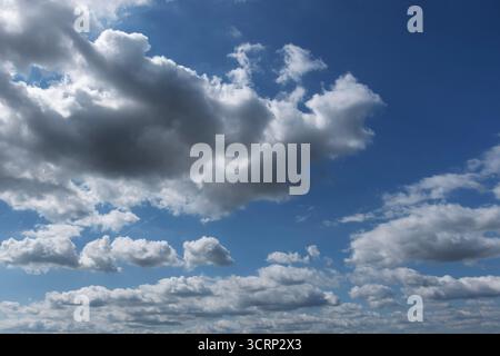 Blue sky with scattered white clouds on a bright sunny day, clear atmosphere background Stock Photo