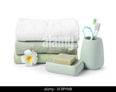 Stack of fresh terry towels, soap, toothbrushes and plumeria flower isolated on white Stock Photo