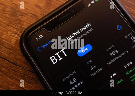 Closeup of BitChat Mesh app page on an iPhone screen, showing download button, rating, and app store listing details. Stock Photo