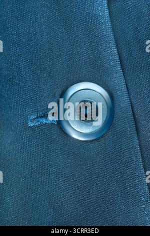 Plastic button on dark blue fabric coat closeup Stock Photo