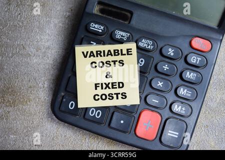 Concept of Variable costs and fixed costs write on sticky notes isolated on Wooden Table. Stock Photo