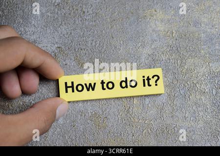 Concept of how to do it write on sticky notes isolated on Wooden Table. Stock Photo