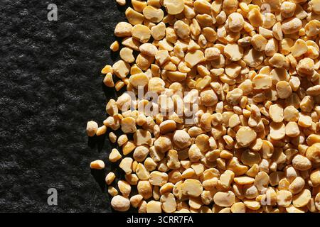 Yellow split peas texture background. Dry legume grains closeup. Plant based protein ingredient for soups and traditional cooking. Stock Photo