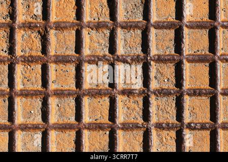 Rusty metal grid texture closeup. Industrial pattern background with weathered steel surface and geometric construction detail outdoors. Stock Photo