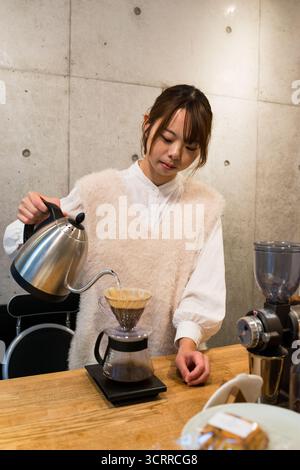 TOKYO, JAPAN - 28 OCTOBER, 2024 - Horizontal picture of a japanese woman preparing pour over coffee in a coffee shop located in Tokyo Stock Photo