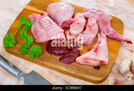 Chopped rabbit with onion, garlic and spices on kitchen board with ...