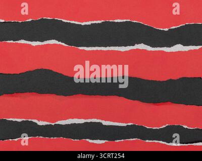 Strips of torn red paper on a black background. Stock Photo