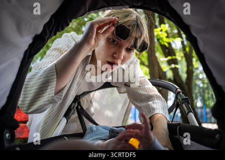 The mother was so surprised that she lifted her glasses to see what had happened to baby. Stock Photo