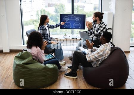 Team discussing automobile design with applause and collaboration Stock Photo