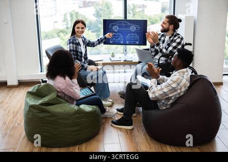 Team discussing automobile design with applause and collaboration Stock Photo