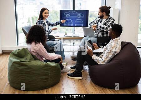Group of diverse young professionals brainstorming car design in workspace Stock Photo