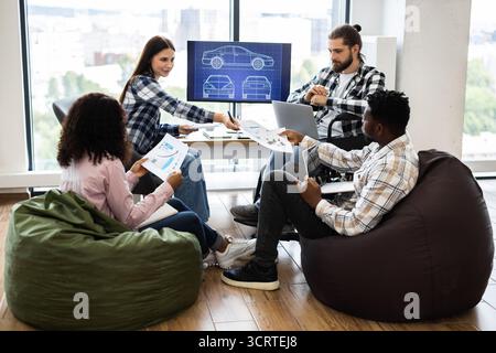 Team brainstorming automotive design in creative workspace with professionals Stock Photo