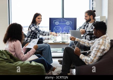 Team collaborating on vehicle design project with diverse participants Stock Photo
