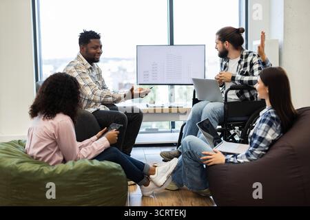 Diverse team collaborating on project in modern work environment Stock Photo