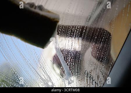 Man Cleaning Window Glass with Sponge during Daytime Stock Photo