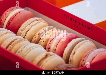 Paris, France - September 5, 2025: Pierre Hermé macarons in assorted colors displayed in signature red box Stock Photo