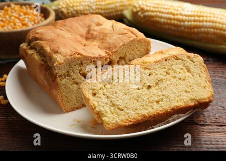 Freshly baked cornbread, cobs and seeds on wooden table, closeup Stock Photo