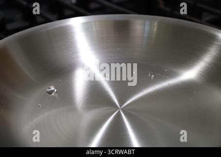 Water Droplets Beading on Stainless Steel Skillet Leidenfrost effect Stock Photo