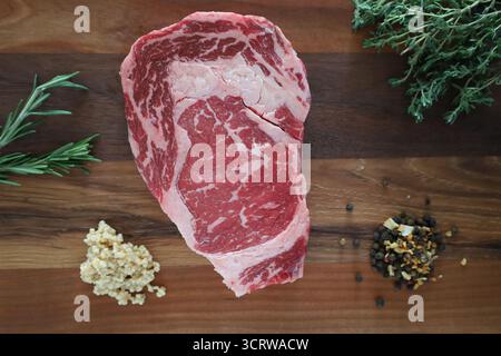 Raw Ribeye Steak with Herbs and Seasonings Stock Photo