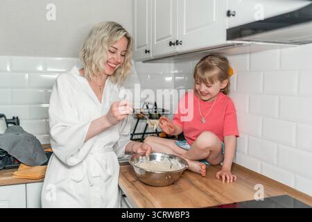 Mom and daughter baking together in kitchen. Happy family. Stock Photo