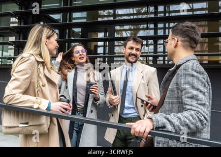IT experts freelance workers innovative technology developers, working on a new project staff meeting with casual talk in formalwear outside office bu Stock Photo