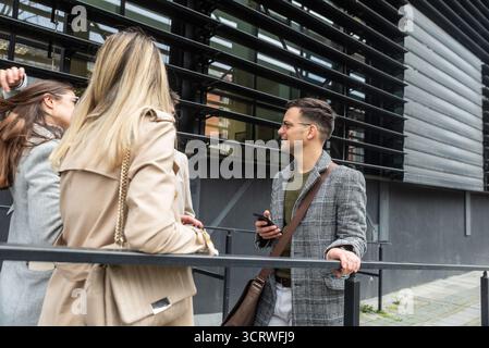 IT experts freelance workers innovative technology developers, working on a new project staff meeting with casual talk in formalwear outside office bu Stock Photo
