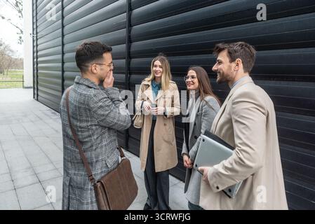 IT experts freelance workers innovative technology developers, working on a new project staff meeting with casual talk in formalwear outside office bu Stock Photo