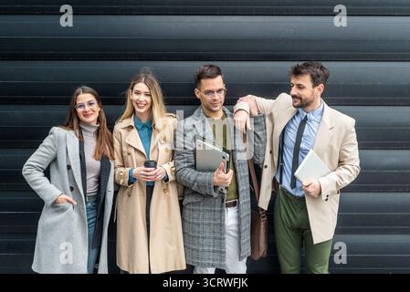 IT experts freelance workers innovative technology developers, working on a new project staff meeting with casual talk in formalwear outside office bu Stock Photo
