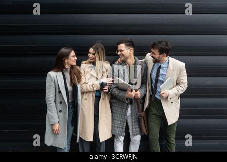 IT experts freelance workers innovative technology developers, working on a new project staff meeting with casual talk in formalwear outside office bu Stock Photo