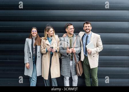 IT experts freelance workers innovative technology developers, working on a new project staff meeting with casual talk in formalwear outside office bu Stock Photo