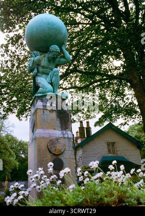 A bronze statue of Hercules wearing the skin of the Nemean lion & holding the celestial globe at Portmeirion architectural village, Gwynedd, Wales, UK Stock Photo