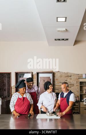 Chefs showing how to cook to students during cooking course Stock Photo