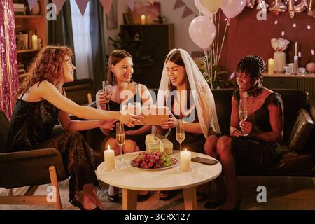 Group of Young Adult Women Celebrating Bachelorette Party and Giving Gifts Stock Photo